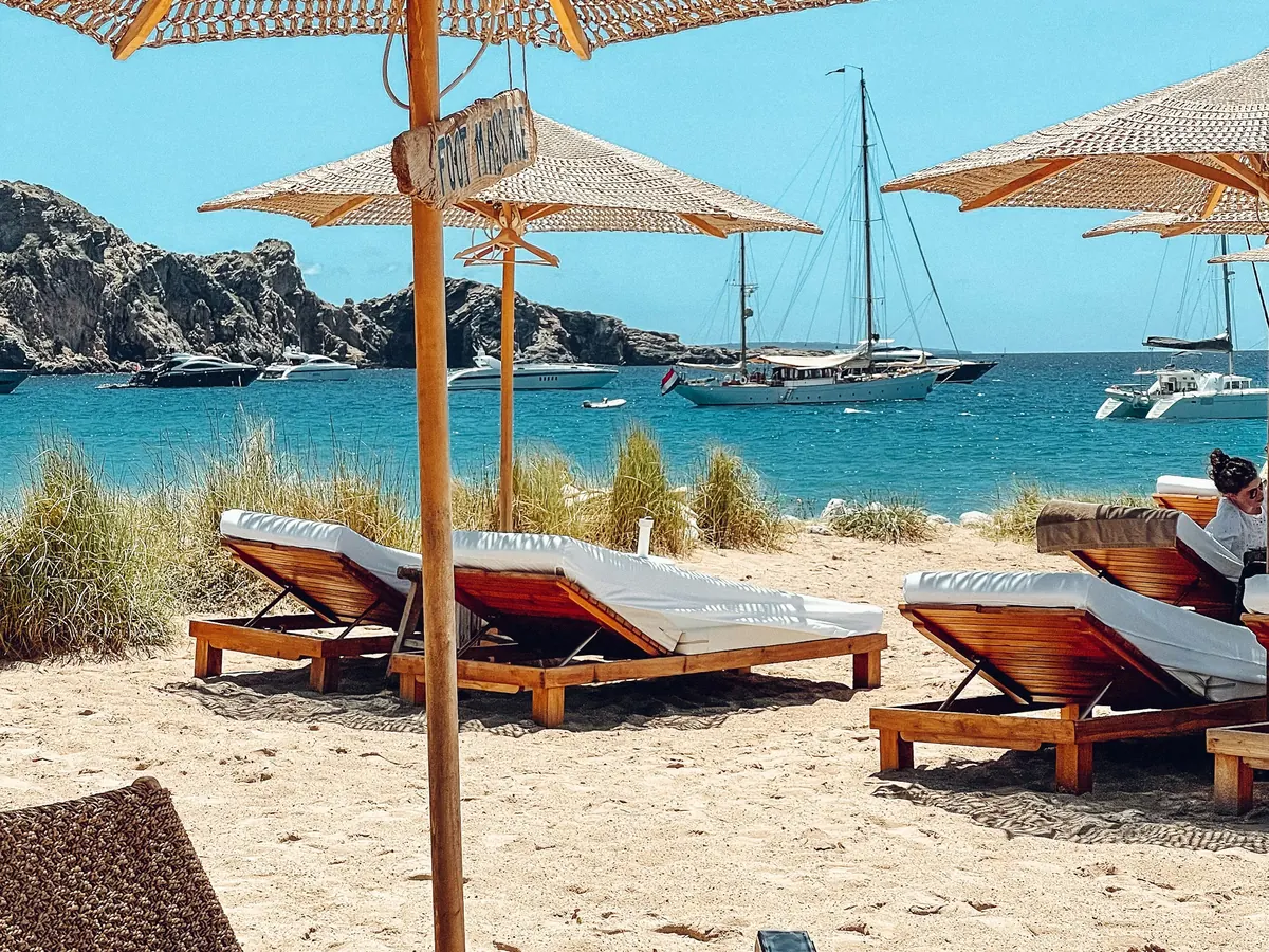 Beach club loungers under straw umbrellas in Ibiza