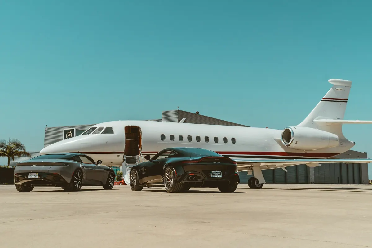 Private jet on the ramp with cars waiting beside it